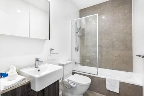 a bathroom with a sink and a toilet and a shower at Central of Toowong Neat Apt Near Station in Brisbane