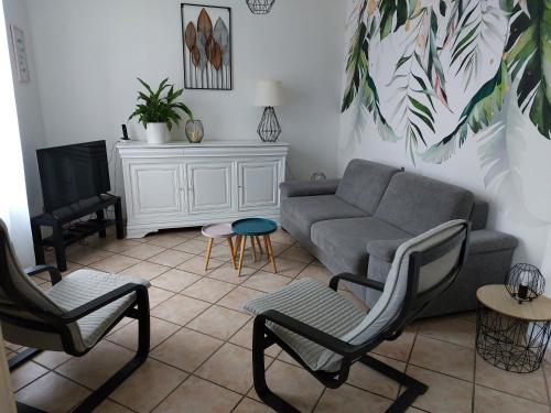 a living room with a couch and two chairs at gite de l épinette in Commentry