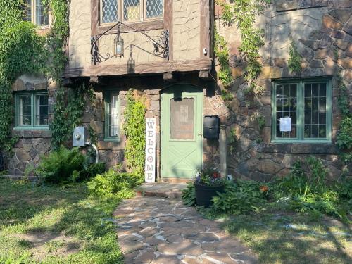 a stone house with a green door and windows at The Brower House in Saint Cloud