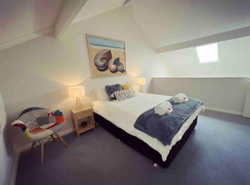 a bedroom with a large bed and a chair at Belluca Villa, Middleton Beach in Albany