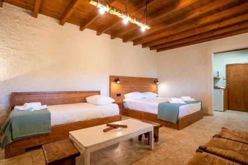 een hotelkamer met 2 bedden en een tafel bij Ktima Asteria in Karistos