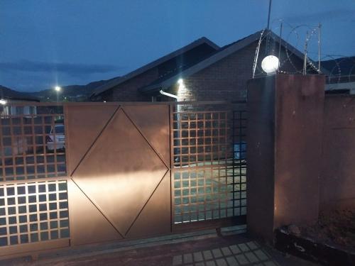 a metal gate in front of a building at night at The Grace quest house in Ngodini