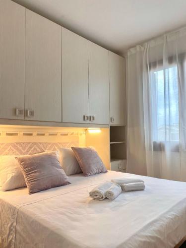 a bedroom with a large bed with two towels on it at CASA GIULIA - Holiday Home in Olbia