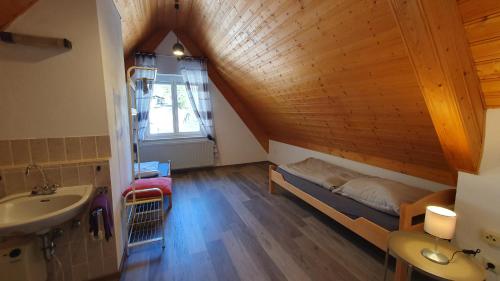 a bathroom with a bed and a sink in a room at Bei München Ferienwohnung in Grafrath Amperschlucht in Grafrath