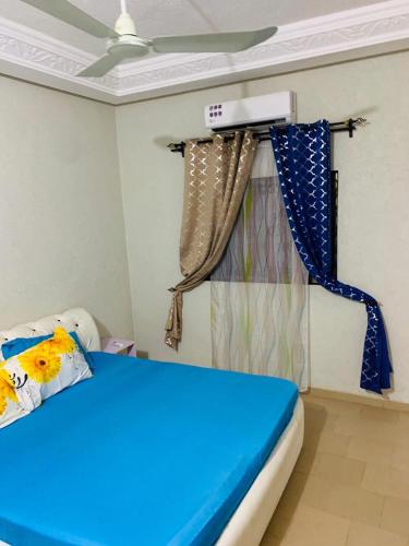 1 dormitorio con cama azul y cortina en Cotonou Luxurious house 1, en Cotonou