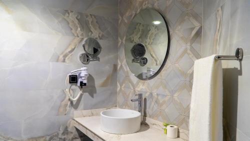 a bathroom with a sink and a mirror at Complexe Hôtelier Sabah in Nouakchott
