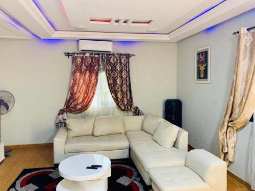 sala de estar con sofá blanco y mesa en Cotonou Luxurious house 1, en Cotonou