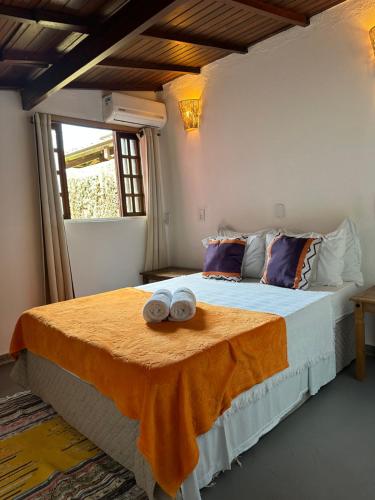 a bedroom with a bed with two towels on it at Pousada Sambaki in Paraty