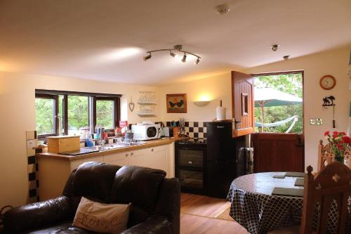 eine Küche mit einem Sofa und eine Küche mit einem Waschbecken in der Unterkunft The Retreat in Llanrhaeadr-ym-Mochnant