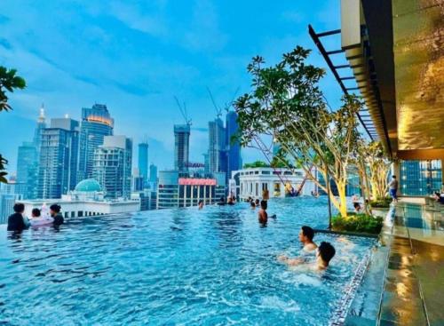 uma piscina com um horizonte urbano ao fundo em Axon Bukit Bintang By moonlight em Kuala Lumpur