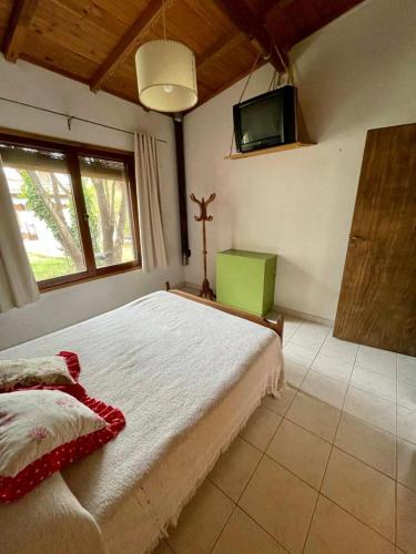 een slaapkamer met een bed en een tv aan de muur bij Verona Cabaña in Necochea