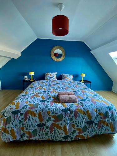 une chambre avec un grand lit avec un mur bleu dans l'établissement Charmant gîte au bord de la Sarthe - 6 personnes, à Fillé