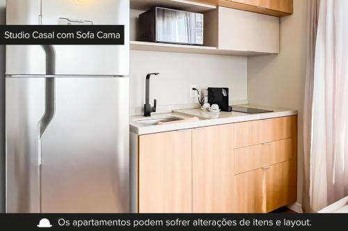 uma cozinha com um frigorífico e um lavatório em Charlie JP Redenção Cidade Baixa em Porto Alegre