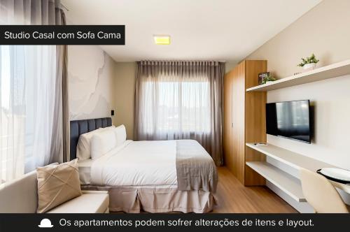 a hotel room with a bed and a tv at Charlie JP Redenção Cidade Baixa in Porto Alegre