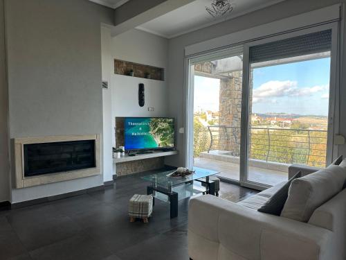 a living room with a couch and a large window at Sunrise Villa in Kassandria