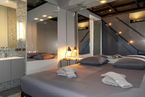 une chambre avec un grand lit avec des serviettes dessus dans l'établissement Loft atypique avec terrasse, calme et cosy, à Paris