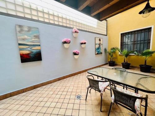 Zimmer mit Tisch, Stühlen und Topfpflanzen in der Unterkunft Central Apartment Private Parking Terrace & AC in Desenzano del Garda