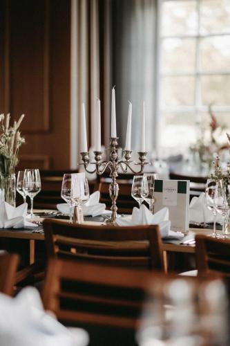 a table with wine glasses and candles on it at Landhaus am Golfpark Inhaber Marko Nolden in Langenhagen