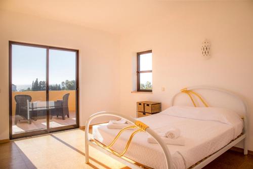 uma cama branca num quarto com uma varanda em D05 - Amadeus Sunset Villa em Mato Porcas