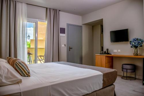 a hotel room with a bed and a television at Olympion Village in Kavos