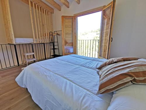 sypialnia z dużym łóżkiem i dużym oknem w obiekcie Cara Norte , Casa Rural-Castillo de Villamalefa 