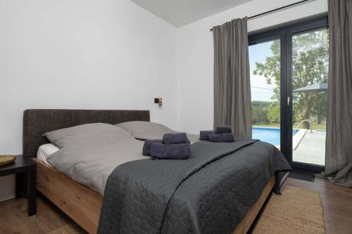 a bedroom with a bed and a large window at Traumhafte Villa Dubi bei Labin in Labin