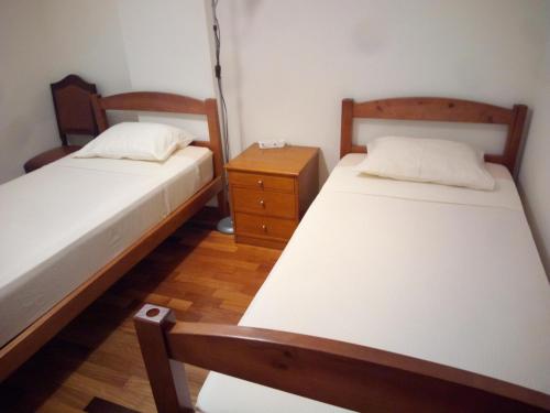 a bedroom with two beds and a night stand at Costa Lodge, private room in Santa Cruz