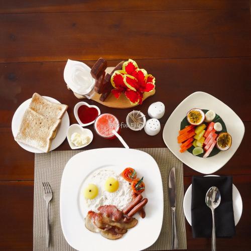 a table with a plate of food with eggs and vegetables at Eyeful Ella Hostel in Ella