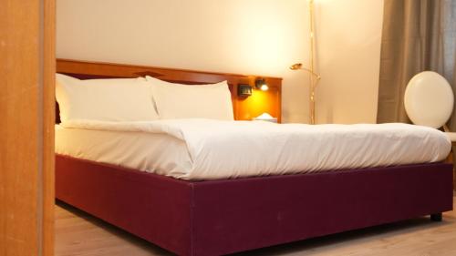 een groot bed in een hotelkamer bij SN Hotel and Restaurant in Langgöns