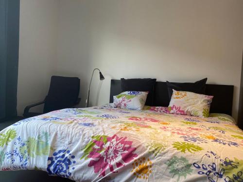 a bed with a colorful comforter and pillows on it at Central Studio in Kortrijk in Kortrijk