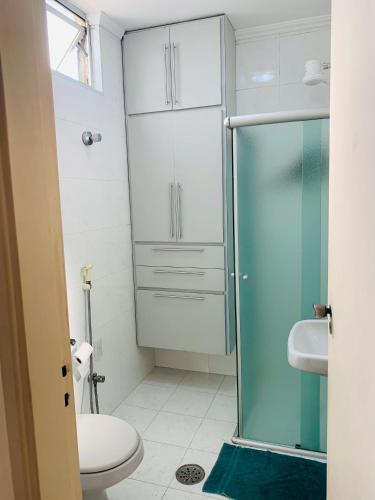 La salle de bains est pourvue de toilettes et d'une douche en verre. dans l'établissement Felicitatem Apartments Higienópolis - Apartamento Compartilhado, à São Paulo