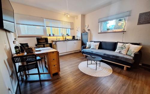 uma sala de estar com um sofá e uma mesa em Ideal für kurze Aufenthalte – gemütliches 1-Zimmer-Apartment em Adelsdorf