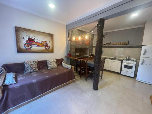 a living room with a couch and a kitchen with a table at Dpto en San Lorenzo in Villa Cura Brochero