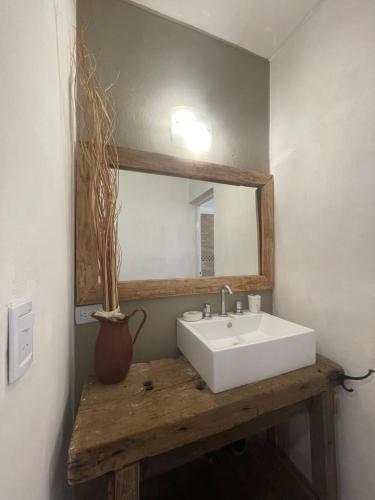 a bathroom with a white sink and a mirror at Dpto en San Lorenzo in Villa Cura Brochero