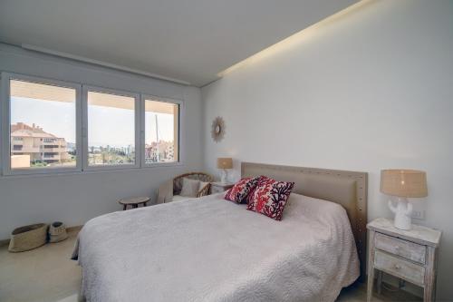 a bedroom with a bed and two windows at Ribera del Marlin - Sotogrande in Sotogrande