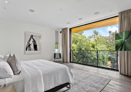 a bedroom with a large bed and a large window at Stunning 5 Bedroom villa In LA in Los Angeles
