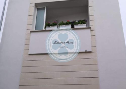 a sign on the side of a building with a window at Seasons Home San Foca in San Foca