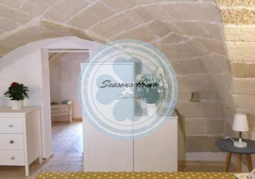 un cartel en una habitación con una pared de piedra en Seasons Home San Foca en San Foca