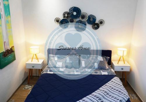 サン・フォカにあるSeasons Home San Focaのベッドルーム1室(青いベッド1台、ナイトスタンド2台付)