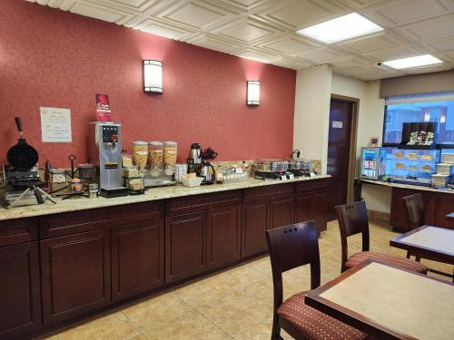a restaurant with a counter and aasteryasteryasteryasteryasteryasteryasteryasteryastery at Best Western Plus Rose City Suites in Welland