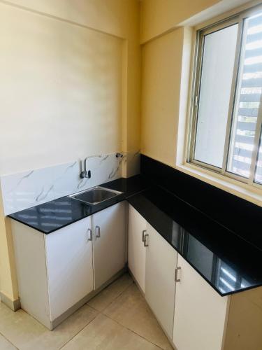 a small kitchen with a sink and a window at REGAL SUITES in Trivandrum