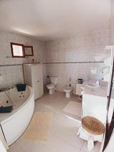a bathroom with a tub and a toilet and a sink at Menzel Caja in Aghīr