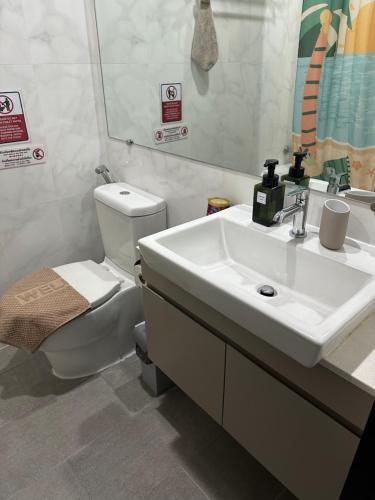 een badkamer met een wastafel, een toilet en een spiegel bij The prio apartment chiangmai airport in Chiang Mai