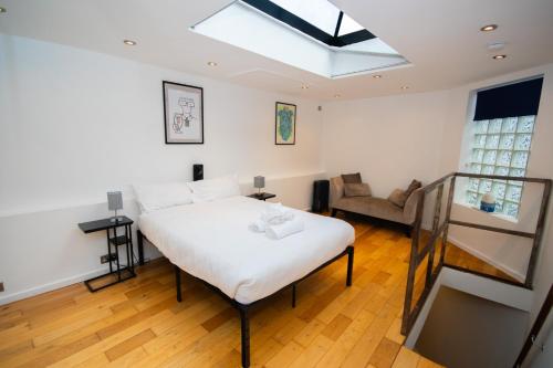 a bedroom with a bed and a couch and a skylight at Modern 1-Bed House in Bristol for 4 people in Bristol