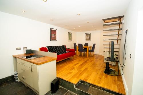 Modern 1-Bed House in Bristol for 4 people في بريستول: غرفة معيشة مع أريكة حمراء وطاولة