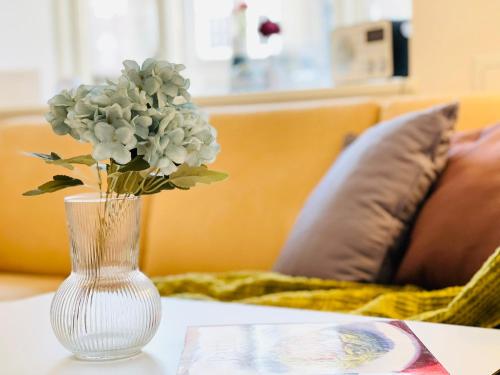 a vase with flowers in it sitting on a table at Scandinavian Apartment Hotel - Industrimuseet - 3 room apartment in Horsens