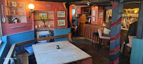 um restaurante com uma mesa de madeira e um bar em Fat Fox inn em Watlington