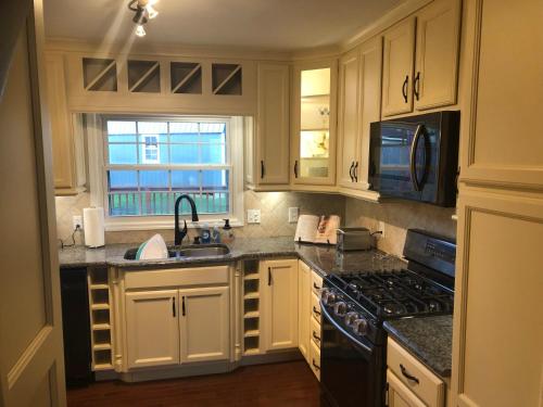 a kitchen with white cabinets and a sink and a stove at Cozy&Quiet*Fenced backyard* 17 Mins UT MktSquare in Knoxville