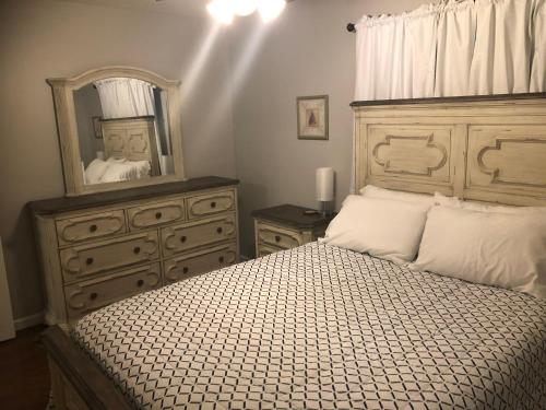 ein Schlafzimmer mit einem Bett mit einer Kommode und einem Spiegel in der Unterkunft Cozy&Quiet*Fenced backyard* 17 Mins UT MktSquare in Knoxville