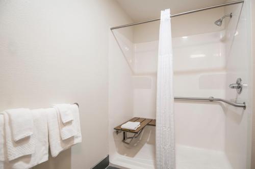 a bathroom with a shower and white towels at Sleep Inn & Suites in Tuscaloosa
